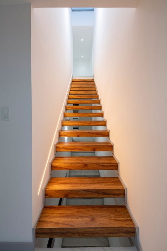 Escalera interior de madera iluminada cenitalmente