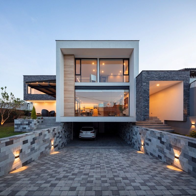 Vivienda unifamiliar moderna iluminada de noche con volumen en voladizo